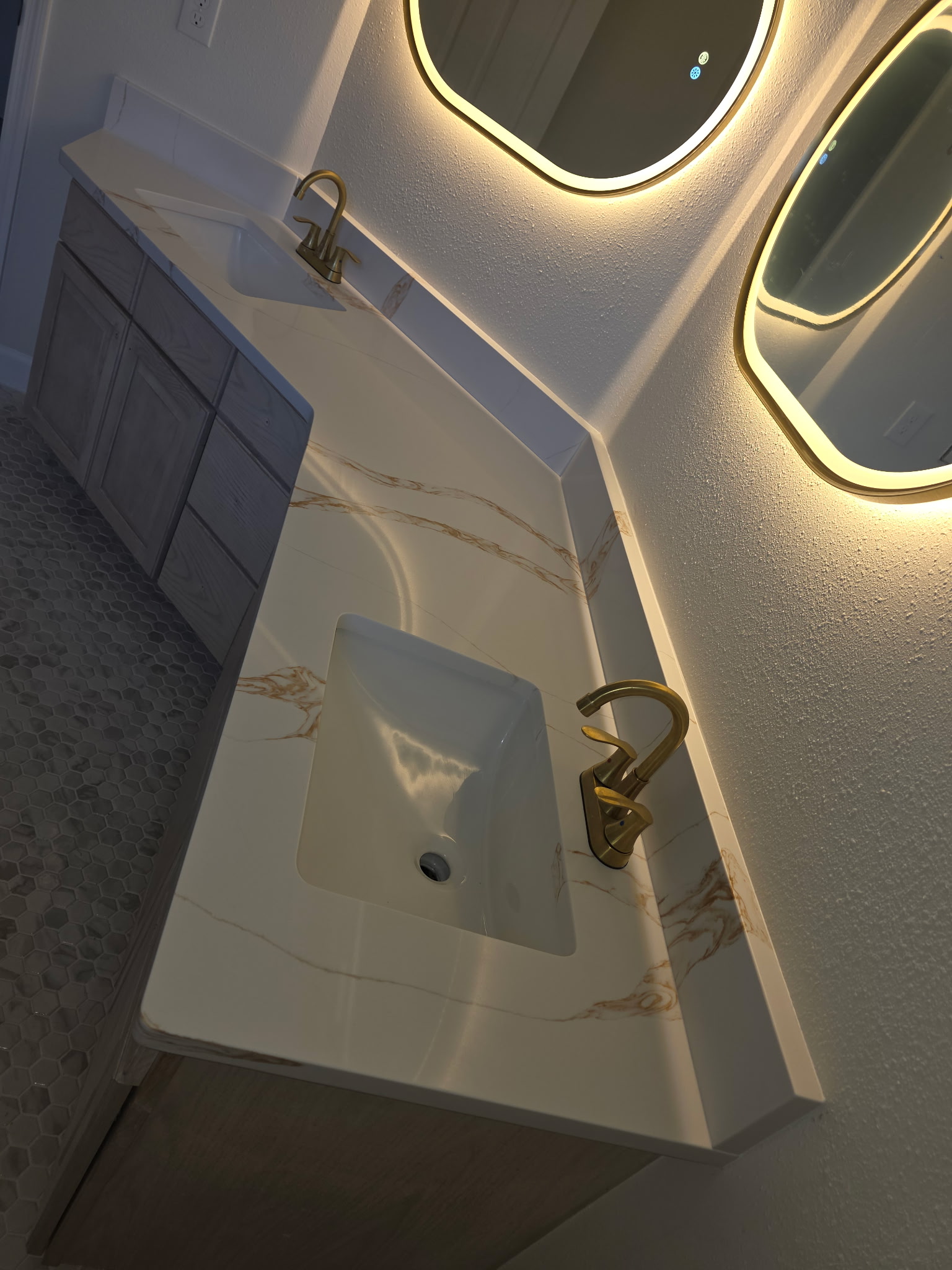 Modern quartz bathroom vanity with gold fixtures and LED mirror