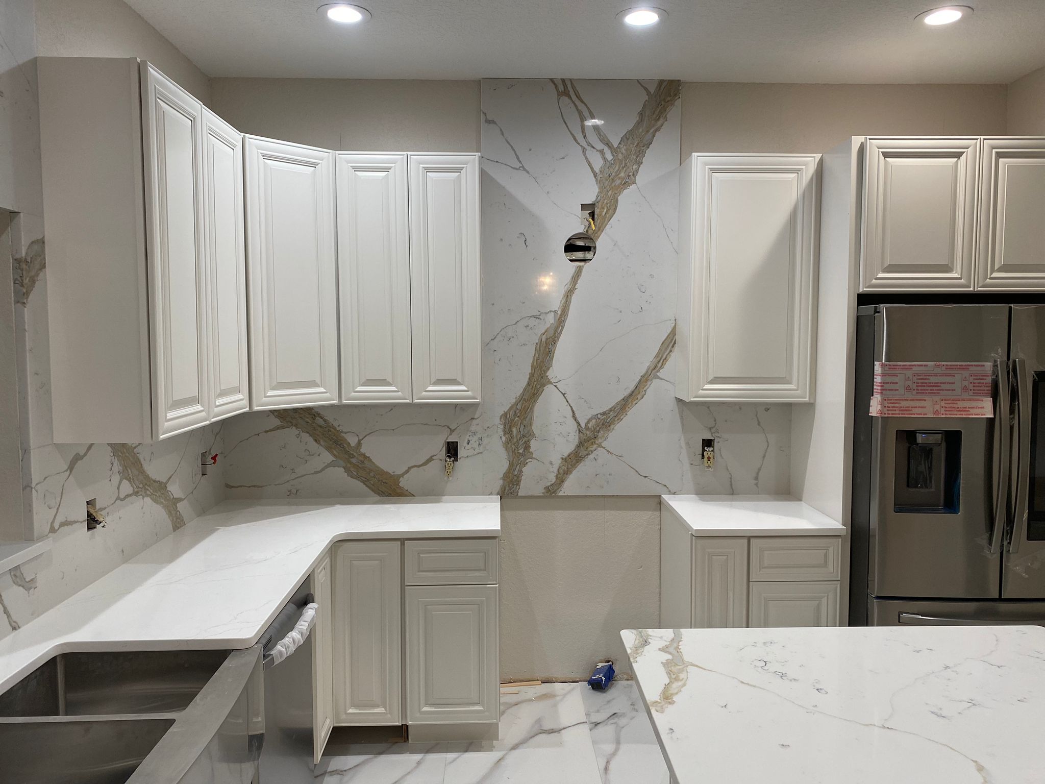Full-slab stone backsplash in kitchen with matching countertop