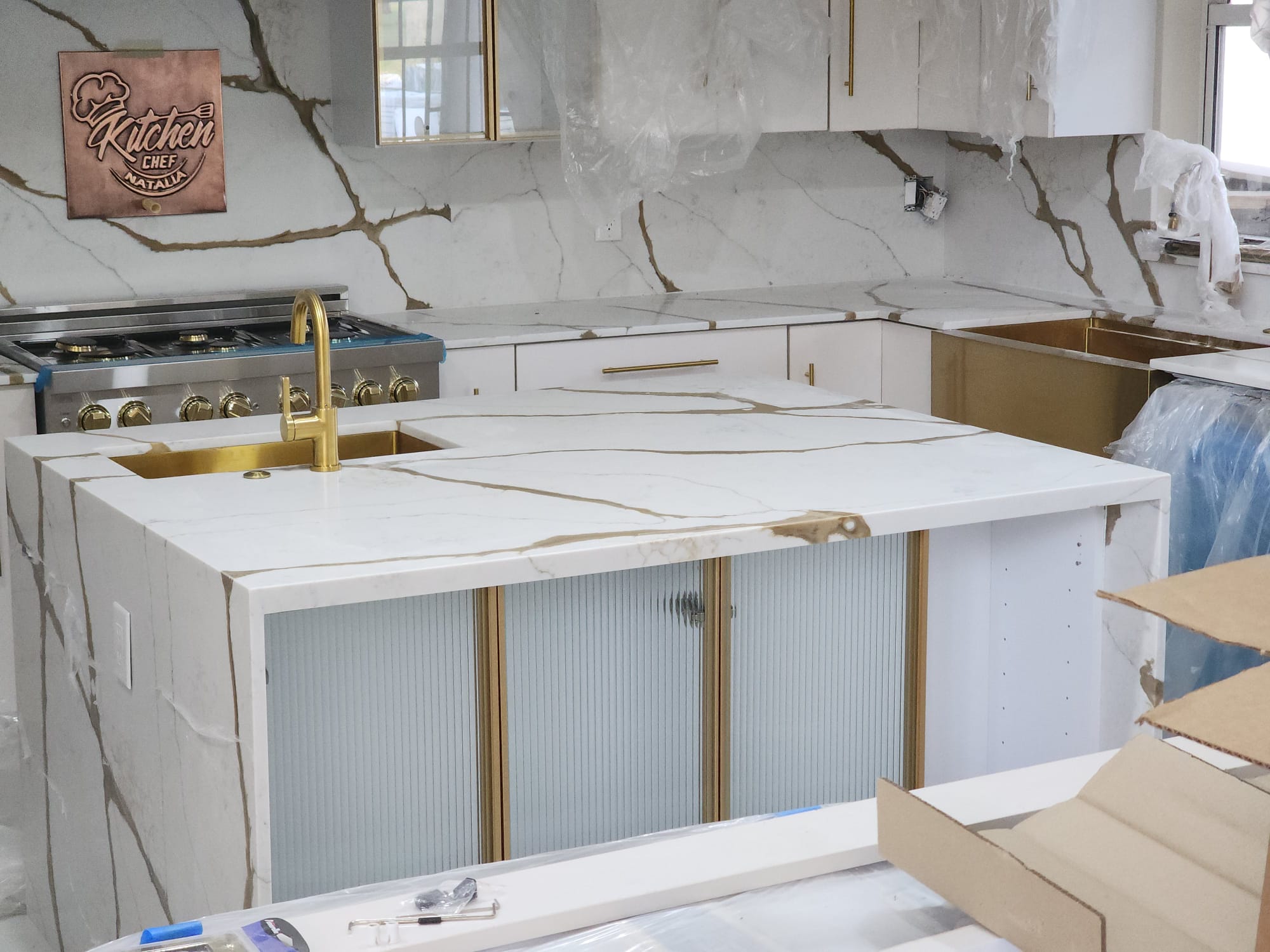 Calacatta marble kitchen countertop with gold brass fixtures